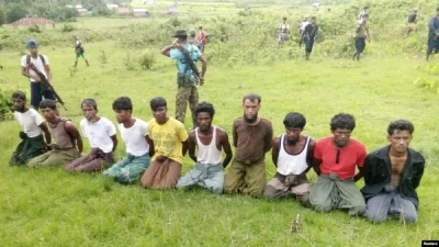 ইনদিন গ্রামে ২ সেপ্টেম্বর ২০১৭ নিরাপত্তা বাহিনীর সদস্যদের পাহারায় দশজন রোহিঙ্গা পুরুষকে হাত বেঁধে হাঁটু গেড়ে বসিয়ে রাখা হয়েছে। ছবি: রয়টার্স।