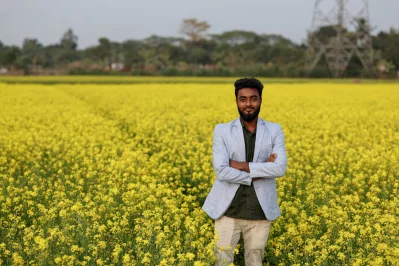 মুন্সিগঞ্জের একটি সরিষা ক্ষেতে ছবি তুলছেন ২১ বছর বয়সী মোহাম্মদ রাকিব, যিনি প্রথমবার ভোটার   ছবি: রয়টার্স